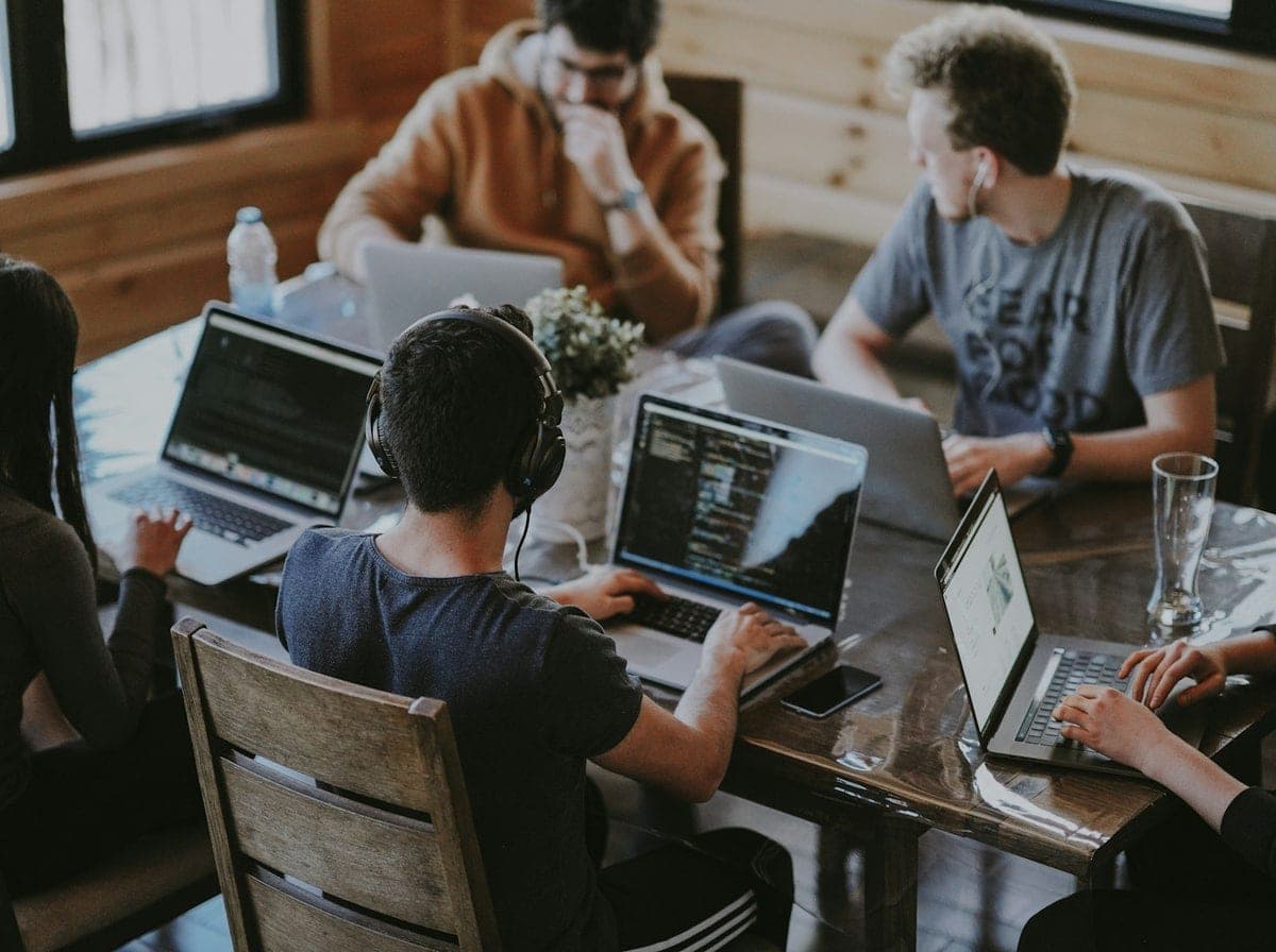 Senior software engineering team collaborating at modern workstations for Alabama technology initiatives
